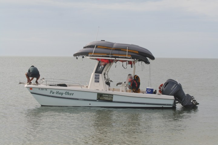 Motorboat named Pa-Hay-Okee with person adjusting rope in calm sea.