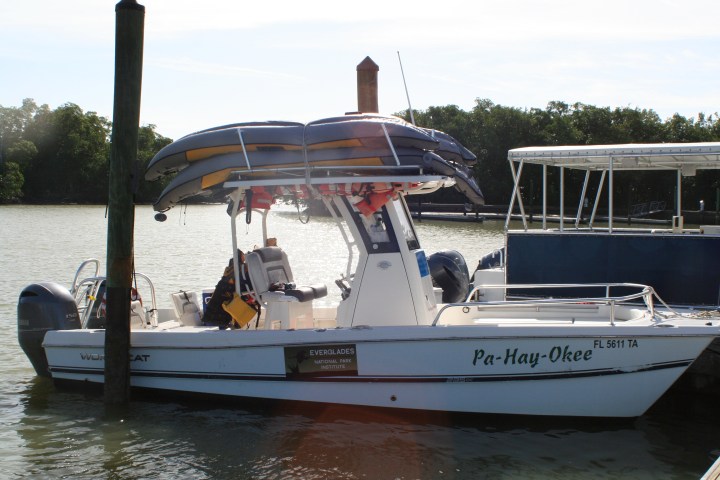 Motorboat named Pa-Hay-Okee docked, with two kayaks stacked on top.