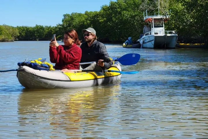 a man riding on the back of a boat in the water