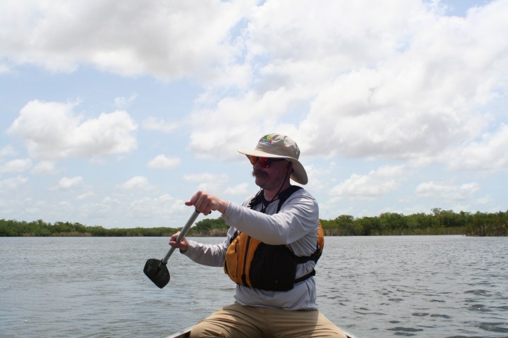a man standing next to a body of water